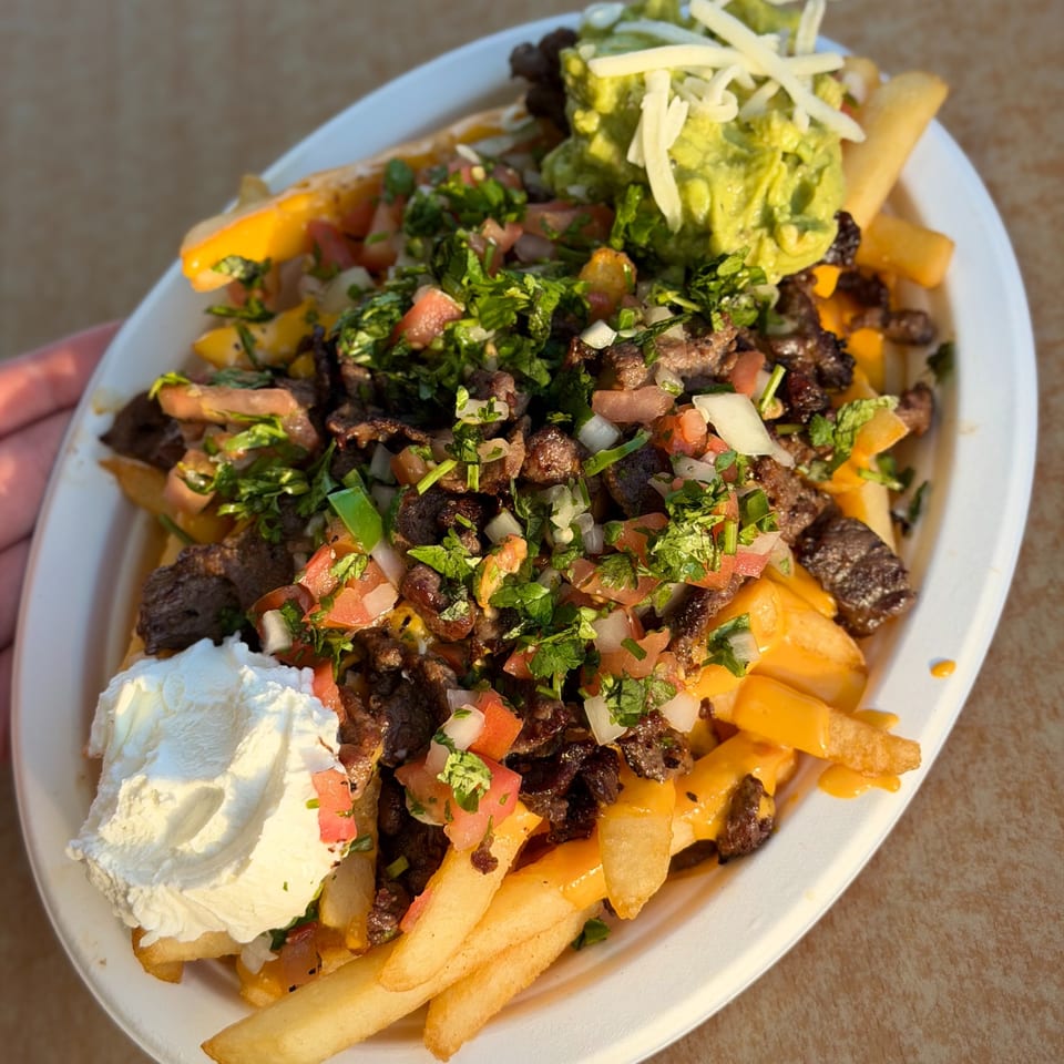 Studio Tacos carne asada fries with guacamole, sour cream, pico de gallo, and cheese.