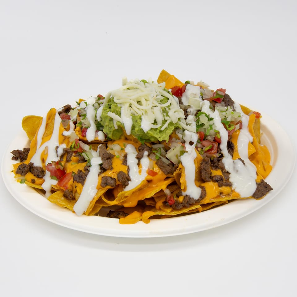 Studio Tacos' beef nachos with melted cheese, guacamole, pico de gallo, and sour cream drizzle.